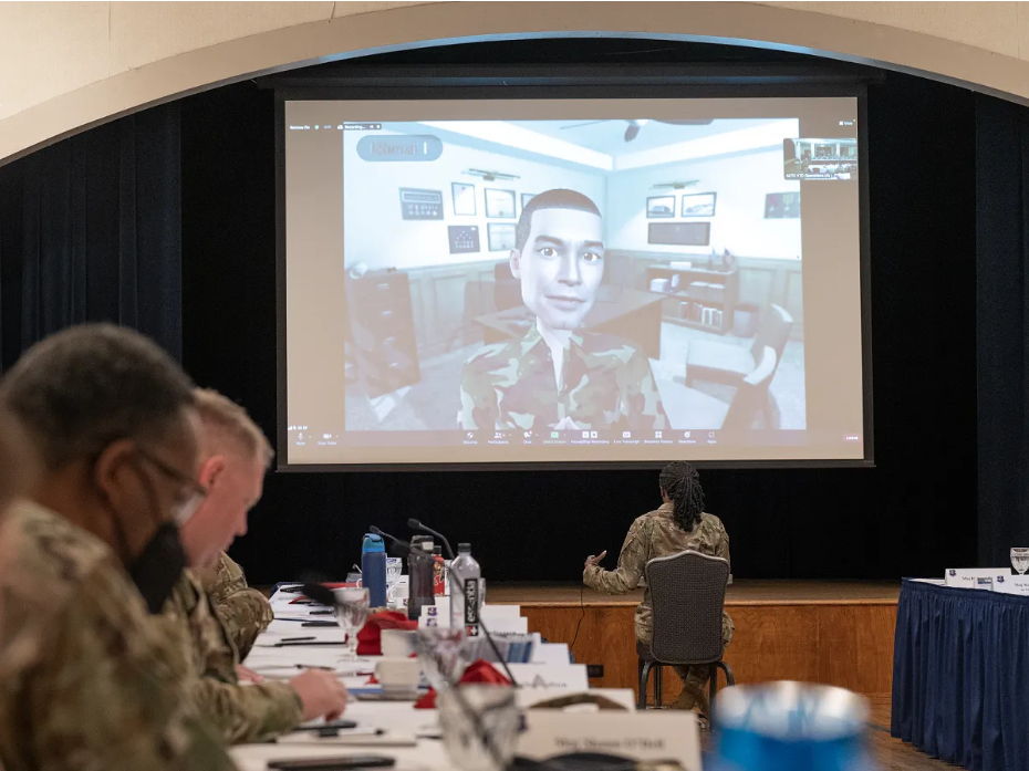 U.S. Air Force personnel participating in Extended Reality leadership training with a virtual avatar displayed on a large screen.
