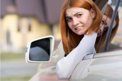 Young woman in a car looking anxious, symbolizing the stress of applying new skills under pressure in XR simulation training (not driving instruction).