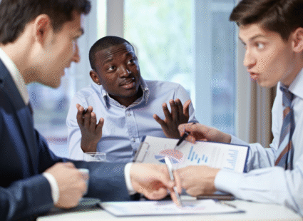 Colleagues in a business meeting debating data while one person looks uncertain