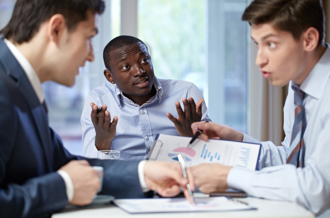 Colleagues in a business meeting debating data while one person looks uncertain