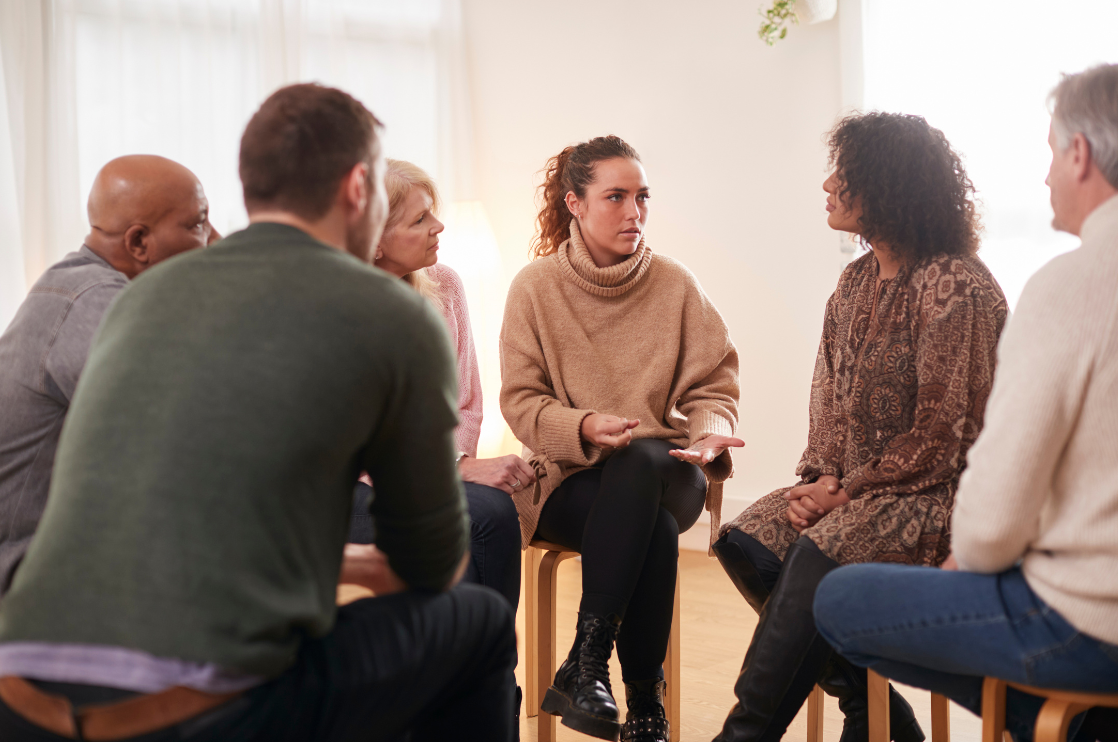 Woman leading a therapeutic group discussion in a community setting