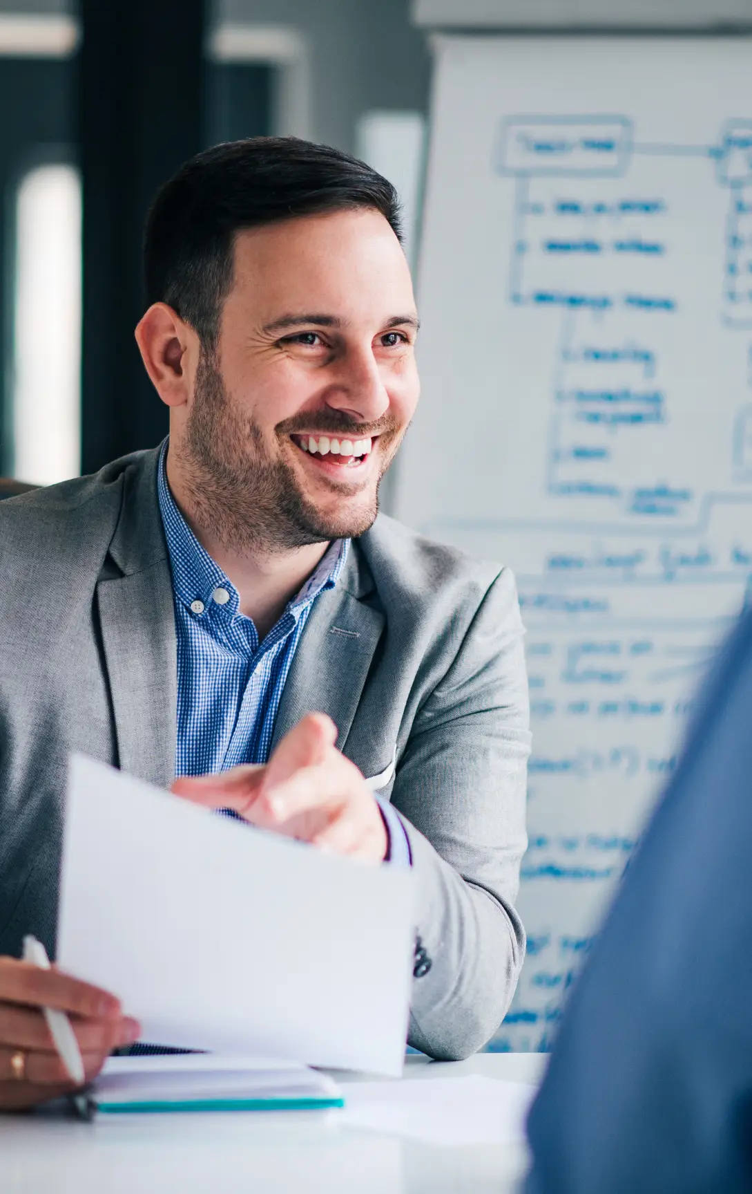 Smiling interviewer discussing candidate performance with strategic notes in background