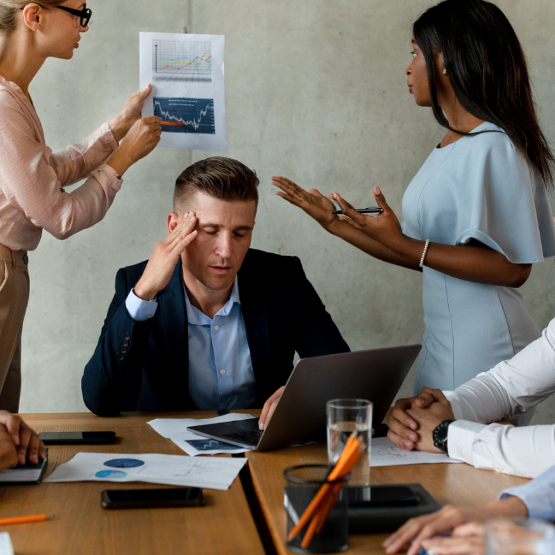 Leader feeling overwhelmed during a high-pressure business meeting